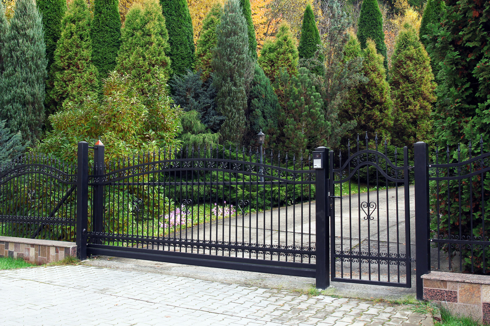 Electric gate at the foot of a stone paved driveway
